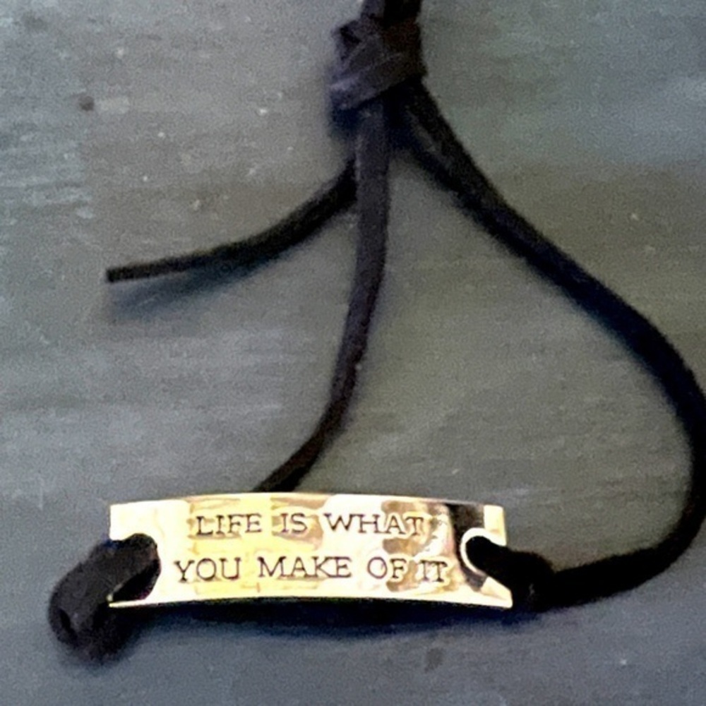 LIFE IS WHAT YOU MAKE OF IT silver plate bracelet with black cord band. NWOT.